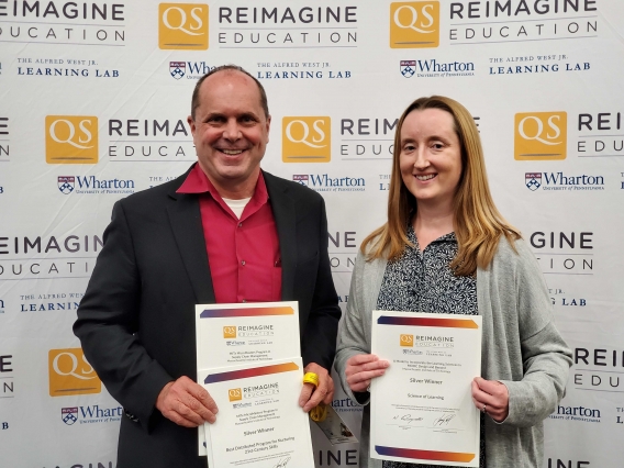 Image of instructors Chris Caplice and Mary Ellen Wiltrout accepting awards