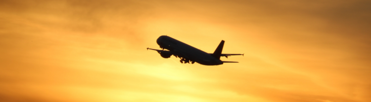 Plane taking off into sunset